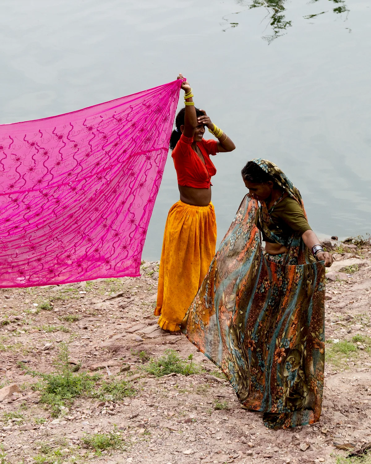 A length of pink cloth carried out to dry in the open, held up against the wind.
