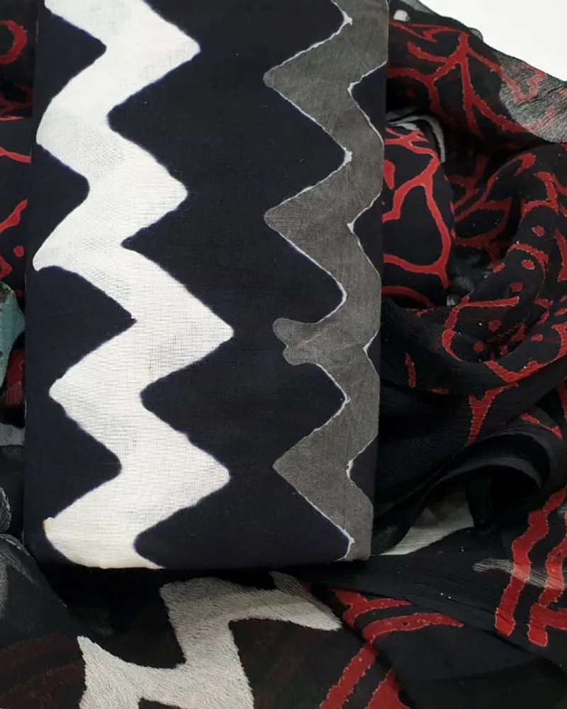 Bagru hand-block cotton in a bold black and white resist beside a madder-printed border.