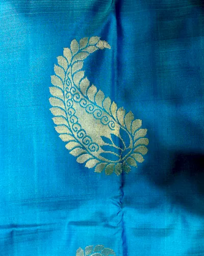 Peacock blue Kanchipuram silk with a large gold mango buti woven into the cloth.