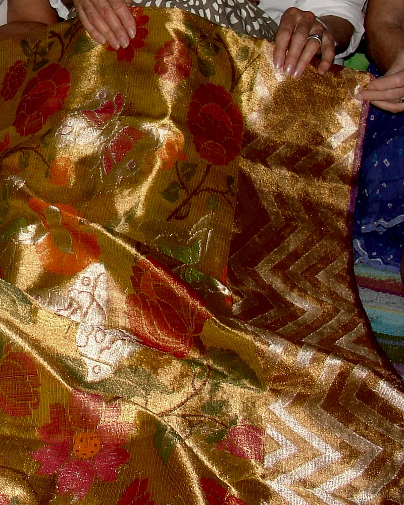 Kota doria worked in gold and madder zari, the square-check weave visible beneath.