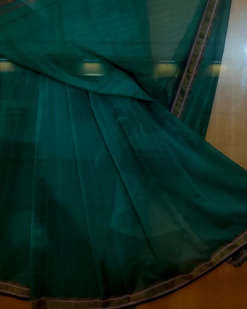 A teal Maheshwari sari with a fine zari border and lengthwise woven stripes.