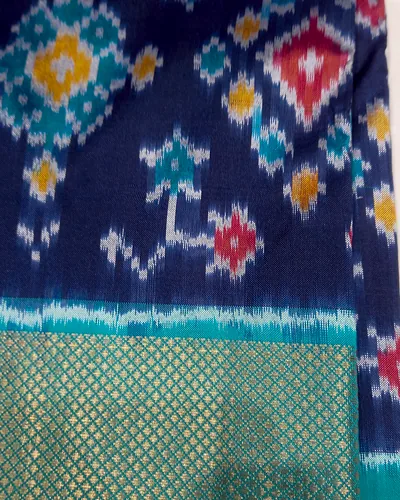 An indigo Pochampally ikat sari with stepped diamond motifs and a teal and gold border.