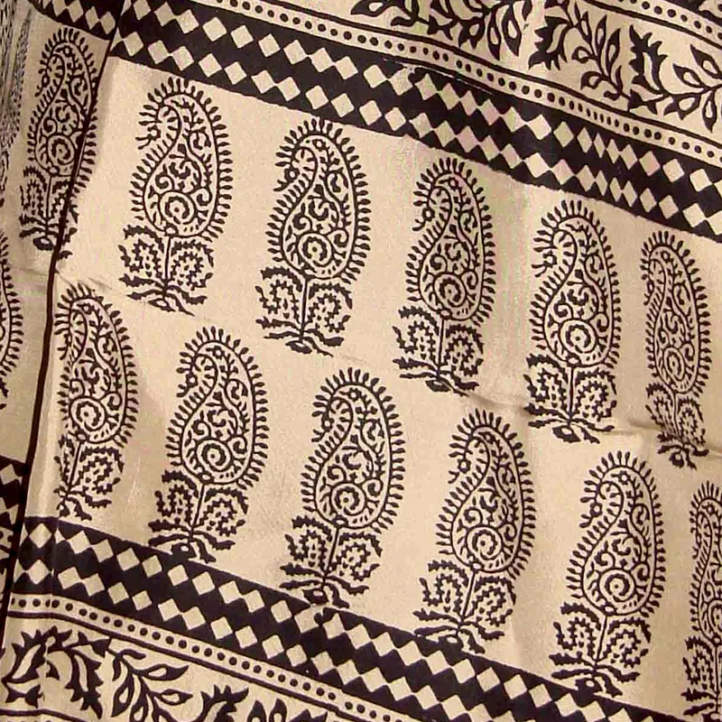 Bagh hand-block print — dark paisley repeats on a cream ground between banded borders.