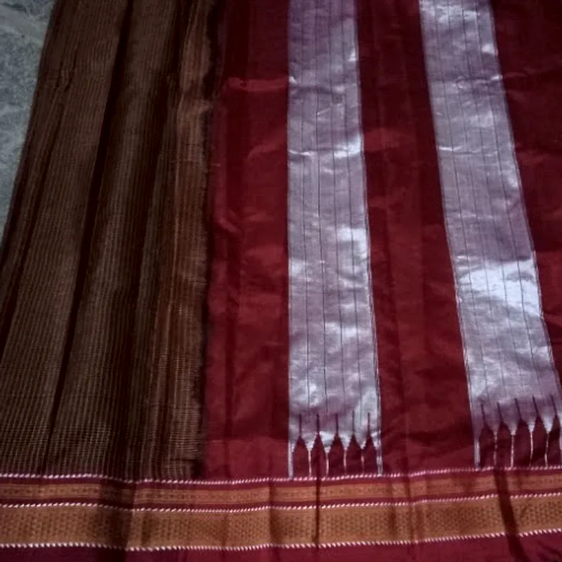 Ilkal cotton woven flat — fine bronze warp stripes beside a deep red pallu banded in silver.