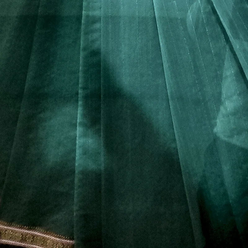 Maheshwari cloth in deep teal with fine woven stripes running into a narrow zari border.
