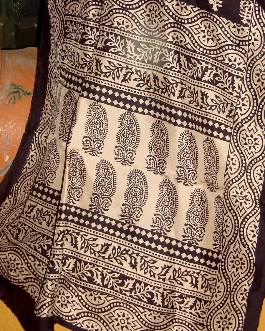 A Bagh-print stole in iron-black paisley on cream, folded to show its banded border.