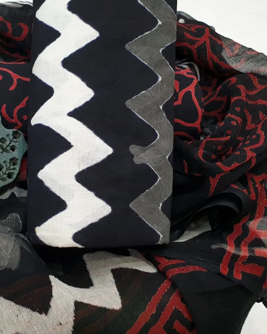 Bagru hand-block cotton in a black and white resist pattern beside a madder-printed border.